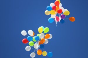 coloured balloons rising in the sky